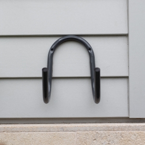 Store a loose garden hose neatly off the ground with the Hoselink Stainless Steel Hose Hanger. The wall-mounted curved support holds coiled hose securely and provides a durable